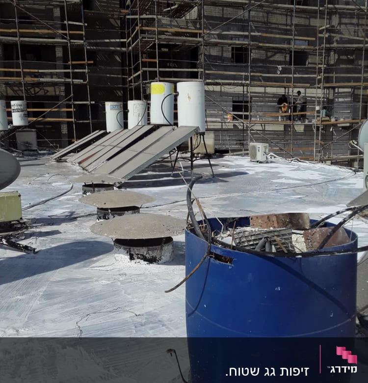 חביות כחולות על גג עם חומרי איטום